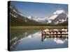 Colorful Canoes Line the Dock at Many Glacier Lodge on Swiftcurrent Lake During Sunrise-Brad Beck-Stretched Canvas