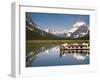 Colorful Canoes Line the Dock at Many Glacier Lodge on Swiftcurrent Lake During Sunrise-Brad Beck-Framed Photographic Print