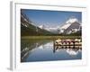 Colorful Canoes Line the Dock at Many Glacier Lodge on Swiftcurrent Lake During Sunrise-Brad Beck-Framed Photographic Print