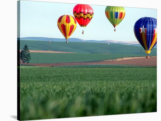 Colorful Hot Air Balloons Float over a Wheat Field in Walla Walla, Washington, USA-William Sutton-Stretched Canvas