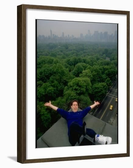 Comedian Jerry Seinfeld Perching Precariously on Roof Ledge Overlooking Central Park-Ted Thai-Framed Premium Photographic Print