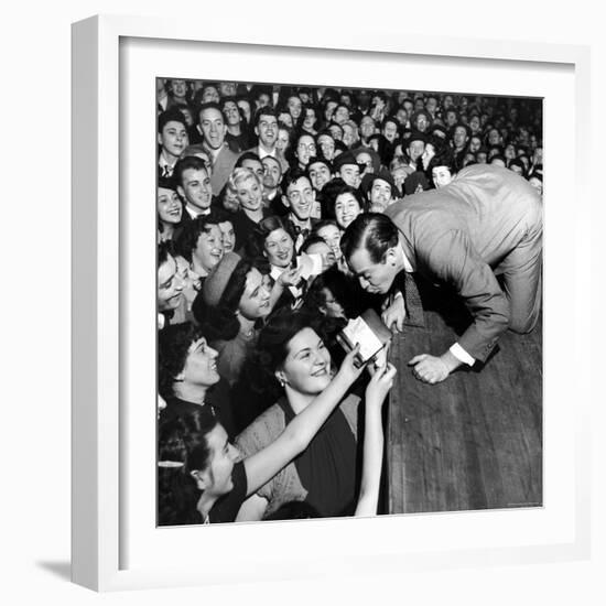 Comedian Milton Berle Trying to Kiss Fans Who Are Asking for Autographs-George Silk-Framed Premium Photographic Print