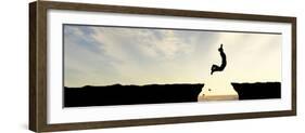 Concept or Conceptual Young Man, Businessman Silhouette Jump Happy from Cliff over Water Gap Sunset-bestdesign36-Framed Photographic Print