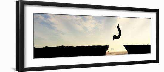 Concept or Conceptual Young Man, Businessman Silhouette Jump Happy from Cliff over Water Gap Sunset-bestdesign36-Framed Photographic Print