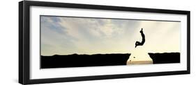 Concept or Conceptual Young Man, Businessman Silhouette Jump Happy from Cliff over Water Gap Sunset-bestdesign36-Framed Photographic Print