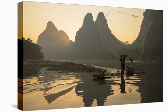 Cormorant Fisherman Throwing Net on Li River at Dawn, Xingping, Yangshuo, Guangxi, China-Ian Trower-Stretched Canvas