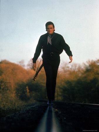 https://imgc.allpostersimages.com/img/posters/country-music-star-johnny-cash-walking-along-line-of-railway-track-with-his-guitar_u-L-P478WH0.jpg?artPerspective=n