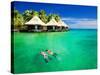 Couple Snorkling in Tropical Lagoon with over Water Bungalows-Martin Valigursky-Stretched Canvas