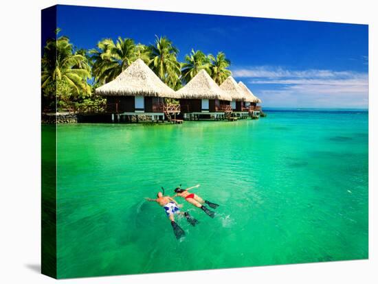 Couple Snorkling in Tropical Lagoon with over Water Bungalows-Martin Valigursky-Stretched Canvas