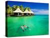 Couple Snorkling in Tropical Lagoon with over Water Bungalows-Martin Valigursky-Stretched Canvas