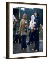 Couple Standing Barefoot on a Road Holding a Bundle and Wine Bottle, Woodstock Music and Art Fair-John Dominis-Framed Premium Photographic Print