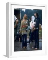 Couple Standing Barefoot on a Road Holding a Bundle and Wine Bottle, Woodstock Music and Art Fair-John Dominis-Framed Photographic Print