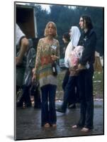 Couple Standing Barefoot on a Road Holding a Bundle and Wine Bottle, Woodstock Music and Art Fair-John Dominis-Mounted Photographic Print