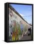 Couple Walking Along the East Side Gallery Berlin Wall Mural, Berlin, Germany, Europe-Simon Montgomery-Framed Stretched Canvas