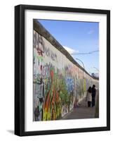 Couple Walking Along the East Side Gallery Berlin Wall Mural, Berlin, Germany, Europe-Simon Montgomery-Framed Photographic Print