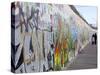 Couple Walking Along the East Side Gallery Berlin Wall Mural, Berlin, Germany, Europe-Simon Montgomery-Stretched Canvas