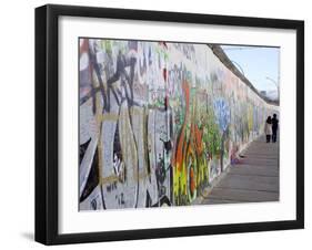 Couple Walking Along the East Side Gallery Berlin Wall Mural, Berlin, Germany, Europe-Simon Montgomery-Framed Photographic Print