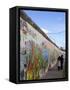 Couple Walking Along the East Side Gallery Berlin Wall Mural, Berlin, Germany, Europe-Simon Montgomery-Framed Stretched Canvas