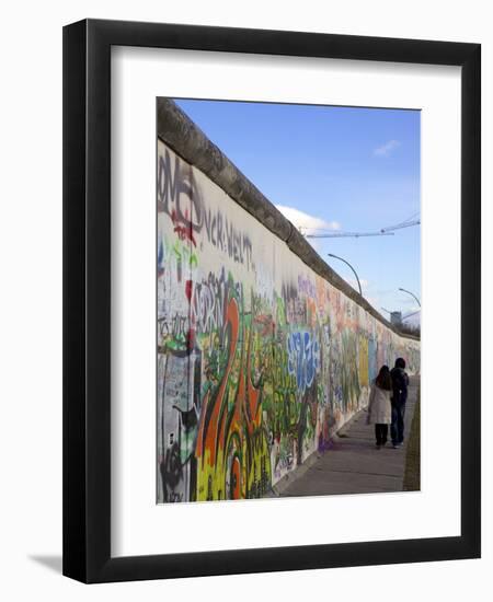 Couple Walking Along the East Side Gallery Berlin Wall Mural, Berlin, Germany, Europe-Simon Montgomery-Framed Photographic Print