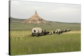 Covered Wagons Passing Chimney Rock, a Landmark on the Oregon Trail, Nebraska-null-Stretched Canvas