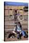 Cowboy and Dog Sitting Against Fence-Darrell Gulin-Stretched Canvas