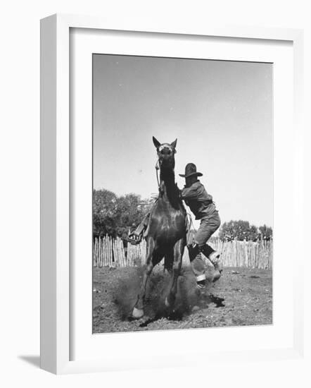 Cowboy Mounting a Horse-Carl Mydans-Framed Photographic Print