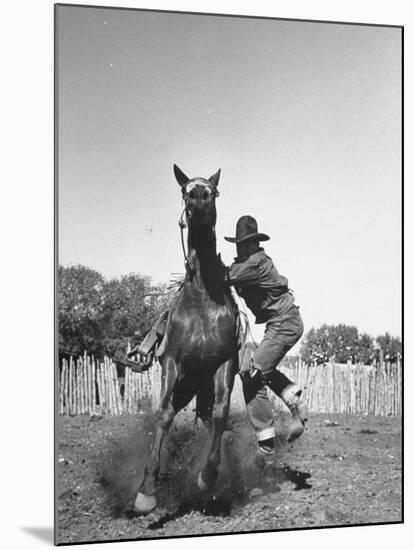Cowboy Mounting a Horse-Carl Mydans-Mounted Photographic Print