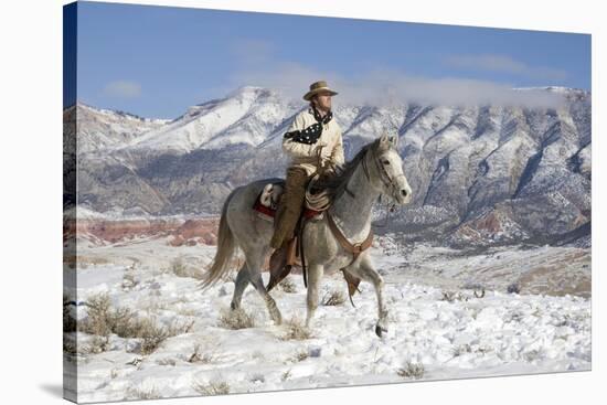 Cowboy On Grey Quarter Horse Trotting In The Snow At Flitner Ranch, Shell, Wyoming-Carol Walker-Stretched Canvas
