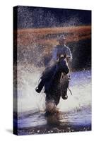 Cowboy Riding Horse Through River-Darrell Gulin-Stretched Canvas