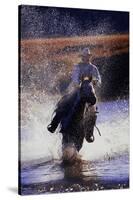 Cowboy Riding Horse Through River-Darrell Gulin-Stretched Canvas