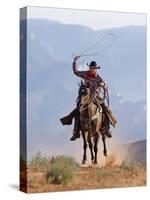 Cowboy Running with Rope Lassoo in Hand, Flitner Ranch, Shell, Wyoming, USA-Carol Walker-Stretched Canvas