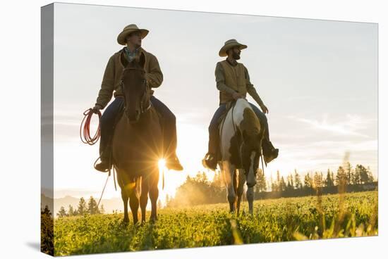 Cowboys Riding across Grassland with Moutains Behind, Early Morning, British Colombia, B.C., Canada-Peter Adams-Stretched Canvas