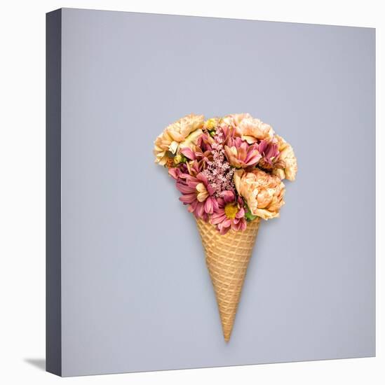 Creative Still Life of an Ice Cream Waffle Cone with Flowers on Grey Background-Fisher Photostudio-Stretched Canvas