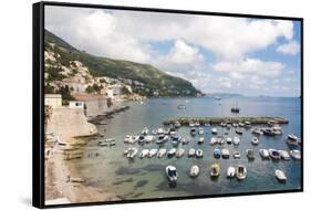 Croatia, Dubrovnik. View of marina and coastline from old city wall. Fisherman stands on shore.-Trish Drury-Framed Stretched Canvas