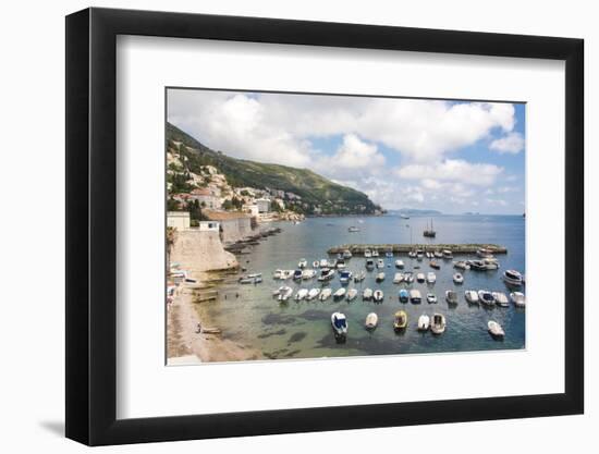 Croatia, Dubrovnik. View of marina and coastline from old city wall. Fisherman stands on shore.-Trish Drury-Framed Photographic Print