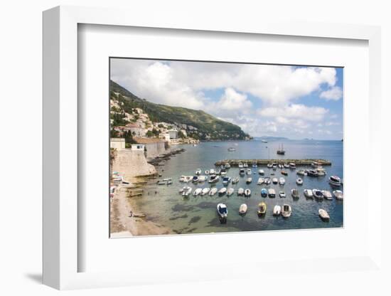 Croatia, Dubrovnik. View of marina and coastline from old city wall. Fisherman stands on shore.-Trish Drury-Framed Photographic Print