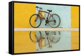 Cuba, Trinidad. Bicycle and reflection against yellow and blue walls.-Brenda Tharp-Framed Stretched Canvas