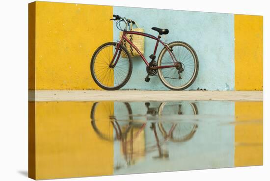 Cuba, Trinidad. Bicycle and reflection against yellow and blue walls.-Brenda Tharp-Stretched Canvas