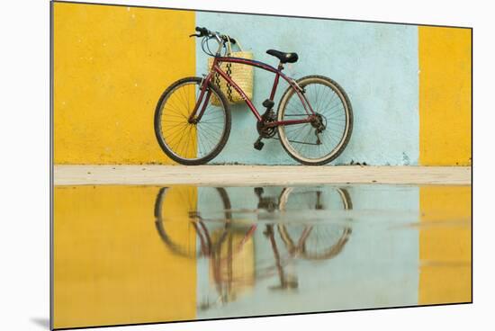 Cuba, Trinidad. Bicycle and reflection against yellow and blue walls.-Brenda Tharp-Mounted Photographic Print