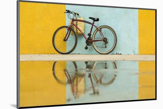 Cuba, Trinidad. Bicycle and reflection against yellow and blue walls.-Brenda Tharp-Mounted Photographic Print