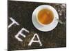 Cup of Black Tea, Surrounded by Tea Leaves with the Word Tea-null-Mounted Photographic Print