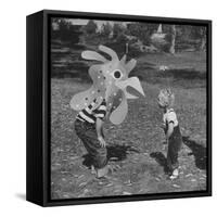 Curious Girl Looking at a Toy Chicken Head Toy by Charles Eames-Allan Grant-Framed Stretched Canvas