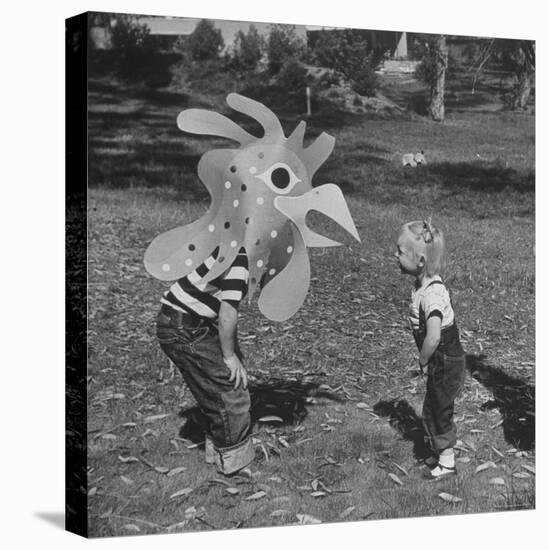 Curious Girl Looking at a Toy Chicken Head Toy by Charles Eames-Allan Grant-Stretched Canvas