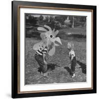 Curious Girl Looking at a Toy Chicken Head Toy by Charles Eames-Allan Grant-Framed Photographic Print