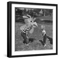 Curious Girl Looking at a Toy Chicken Head Toy by Charles Eames-Allan Grant-Framed Photographic Print