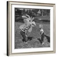 Curious Girl Looking at a Toy Chicken Head Toy by Charles Eames-Allan Grant-Framed Photographic Print