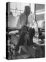 Custom Tailor Ernest Preedik Sitting on Table and Working in Factory-Ralph Morse-Stretched Canvas