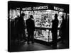 Customers Peering at the Wares Inside a Small, Brightly Lit Times Square Jewelry and Watch Shop-Peter Stackpole-Stretched Canvas