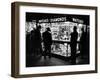 Customers Peering at the Wares Inside a Small, Brightly Lit Times Square Jewelry and Watch Shop-Peter Stackpole-Framed Photographic Print