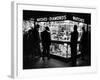 Customers Peering at the Wares Inside a Small, Brightly Lit Times Square Jewelry and Watch Shop-Peter Stackpole-Framed Photographic Print